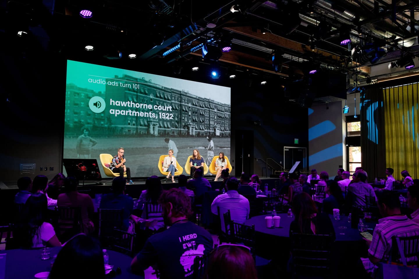 A panel on stage in front of a full room