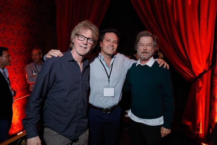 Three guests in front of a red curtain